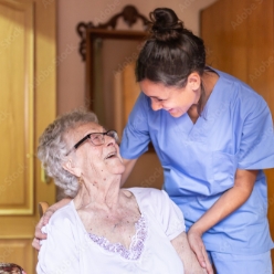 red-haired woman in scrubs supports older woman using crutches