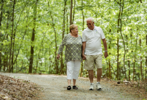 senior couple walking outdoors on wooded trail